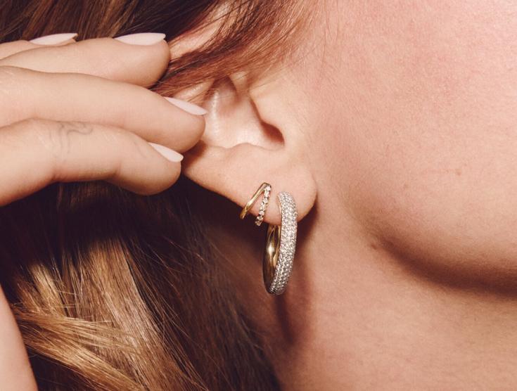 Model wearing yellow gold hoop diamond earrings