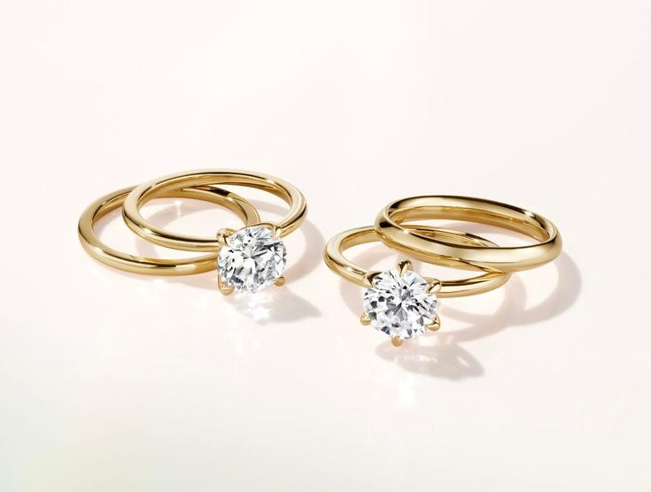 Two yellow gold lab diamond engagement rings and wedding rings.