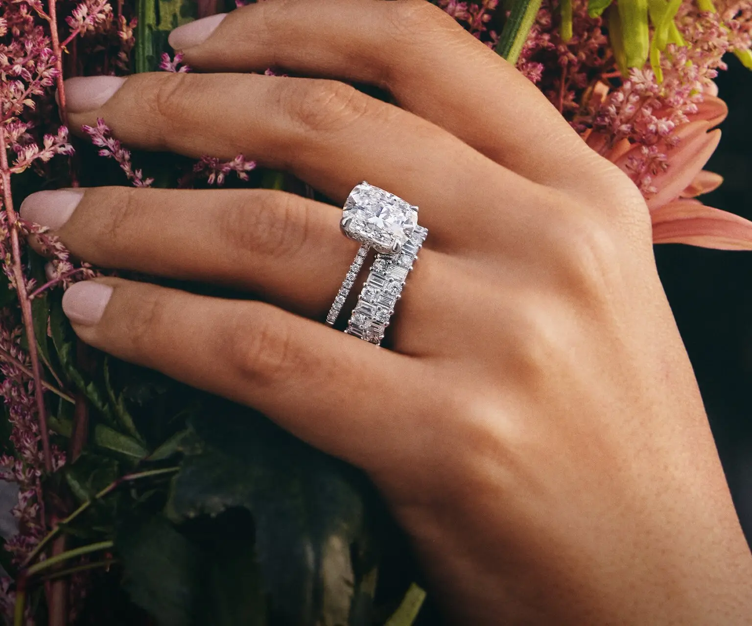 Model wearing a diamond engagement ring and wedding ring 