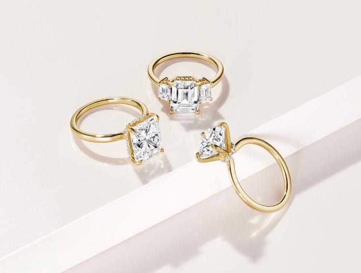 Three yellow gold lab diamond engagement rings.