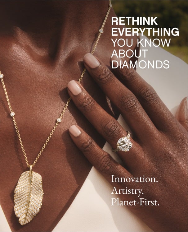 Model wearing diamond engagement ring and gold necklace from the Jane Goodall collection